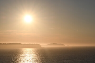 Fototapeta na wymiar Sunset over islands shrouded with mist