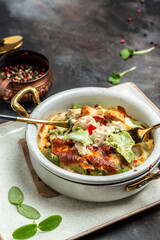 hot spinach crepes or pancakes with chicken and mushrooms baked with cheese. cooking concept, vertical image. copy space