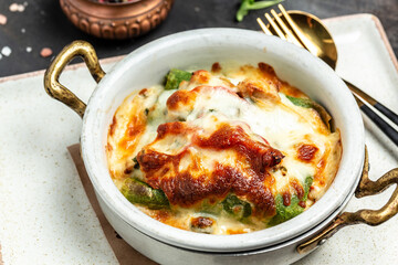 Baked hot spinach crepes roll with chicken, cheese, mushroom and bechamel sauce. Food recipe background. Close up