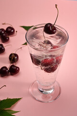 Fresh cherry cocktail on pink background.