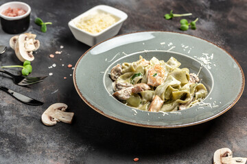 Tagiatelle pasta with creamy sauce with porcini mushrooms and chicken. Pasta fettuccine alfredo. Italian cuisine. banner, menu, recipe place for text, top view - obrazy, fototapety, plakaty
