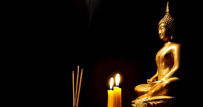 Stop motion photo,Burning incense and candles to pay homage to the Buddha image , black background,floating incense smoke