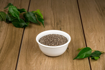 Tazón de cerámica blanca con semilla de chia sobre madera