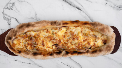 Gourmet cuisine. Top view of a homemade mozzarella, provolone, blue cheese and onion pizza on the white marble table.