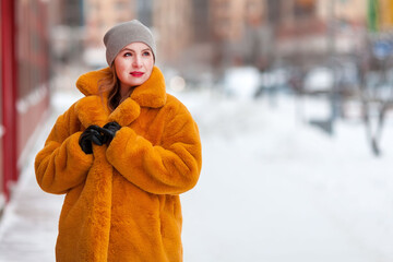 Portrait of happy woman in red faux fur coat in winter outdoors