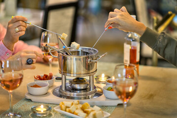 Olla de fondue con copas de vino rosado