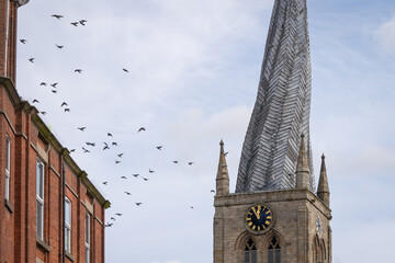 Chesterfield crooked spire church with birds flying in sky. St Marys Church Chesterfield,...