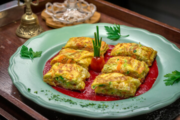 Desayuno especial de omelette de huevos revueltos con verduras sobre salsa de tomate y plato verde