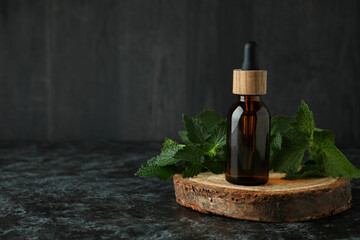 Bottle of nettle essence oil on black smokey table