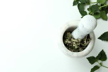 Mortar with nettle on white background, space for text
