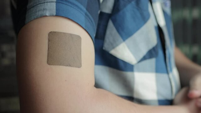 A man puts an anti-smoking plaster on his hand, close-up. Quitting smoking