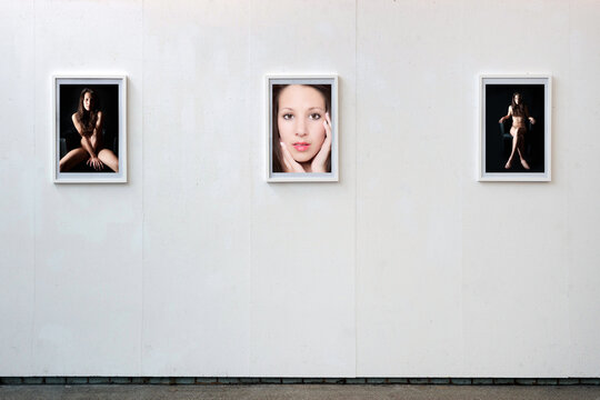 A beauty portrait and two classic nude photos hanging on a white wall, the private parts of the model are not visible