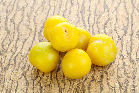 Ripe sweet yellow plum heap over background