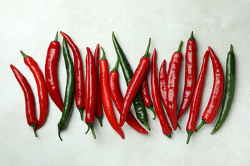 Red and green peppers on white textured background