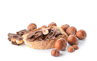 Bread with tasty chocolate paste and hazelnuts on white background