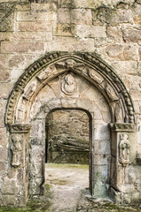 Fototapeta na wymiar Erosionada puerta con arco de estilo románico en las ruinas del antiguo convento de San Domingos en Pontevedra, España