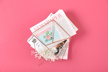 Stand with newspapers and floral decor on color background