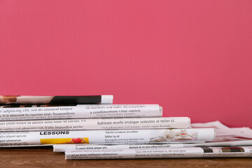 Newspapers on table near color wall
