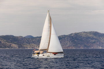 Fototapeta premium Yacht sailing at sunset during a storm. Luxury vacation at sea