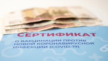 Close-up of the vaccination certificate and money. Sale of fake forms by scammers