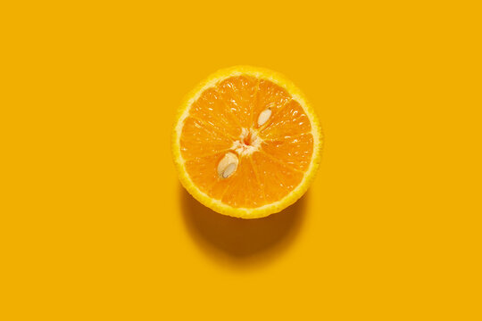 Creative concept food health diet photo of cut raw orange fruit on orange background.