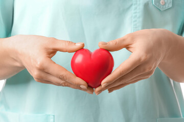 Female cardiologist with red heart, closeup