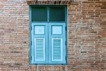 European antique blue wooden shutters window and brown stone brick wall