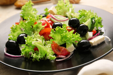 Plate with tasty Greek salad on table, closeup