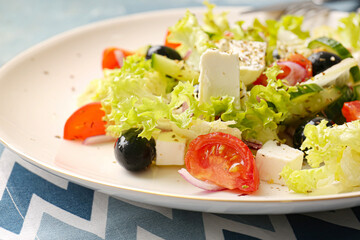 Plate with tasty Greek salad on color background, closeup