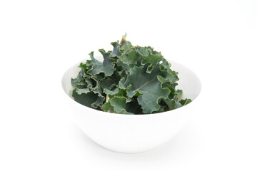 Fresh kale leaves in white bowl isolated on white background. Healthy food concept