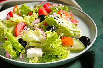 Plate with tasty Greek salad on color background, closeup