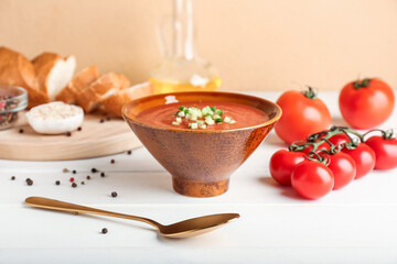 Bowl with tasty gazpacho on light wooden background