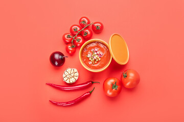 Bowl with tasty gazpacho and vegetables on color background