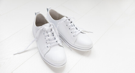 White leather sneakers with laces  on white background. banner