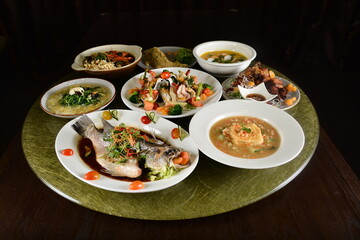 asian restaurant premium banquet cafe halal chinese menu in set with grouper fish, pork meat, fried vegetables, bean curd tofu, seafood soup and appetiser on gold dining table