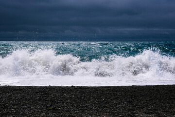 Amazing sea wave on the black sand coastline. 