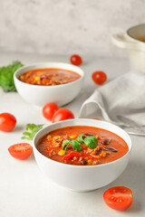 Bowls with delicious chili con carne on light background