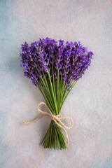 Bouquet of lavender flowers tied with rope on colored decorative plaster background