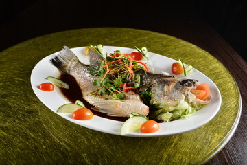 asian premium banquet menu chinese steamed big fresh whole grouper fish in dark soy sauce on gold background dining table