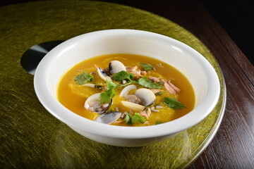 asian premium banquet menu double boiled seafood with shell yellow stock pumpkin thick soup on gold background dining table