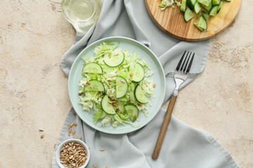 Plate with tasty cabbage salad and ingredients on light table