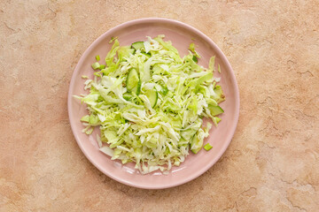 Plate with tasty cabbage salad on color background