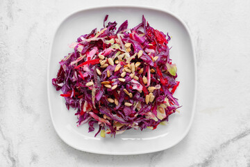 Plate with tasty cabbage salad on light background