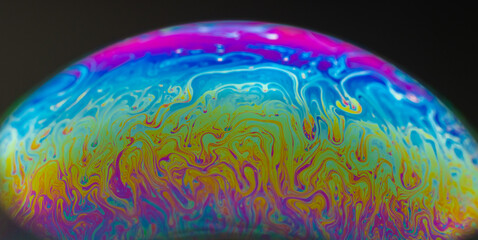 Vivid rainbow colours of a Macro soap bubbles creating psychedelic patterns under light dome - obrazy, fototapety, plakaty