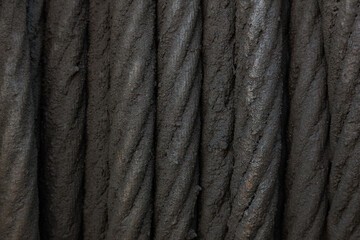 Close-up of a steel cable oiled with black grease.