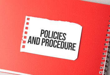 The word Policies and Procedure on torn paper on red notepad,.