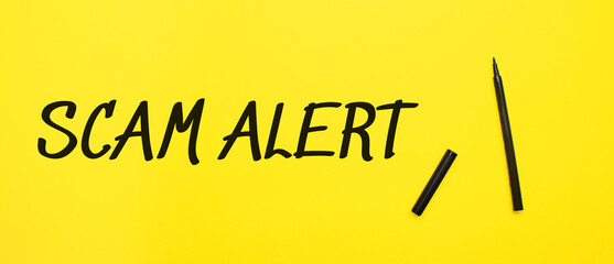 scam alert sign with black marker on a yellow background. With copy space ready for your text. - obrazy, fototapety, plakaty
