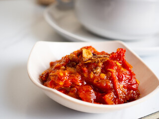 Vegetables soup that contain sausage, broccoli, carrots, etc on a white porcelain bowl