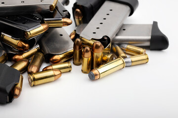 Pile of gun magazines and bullets on white background