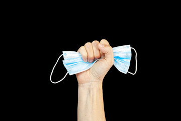 Fight to virus. Victory hand with protective mask in fist isolated on black. Coronavirus quarantine...
